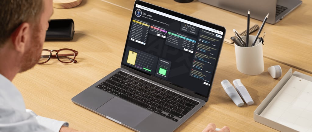 A person using a laptop with a data dashboard and CRM software on a wooden office desk.