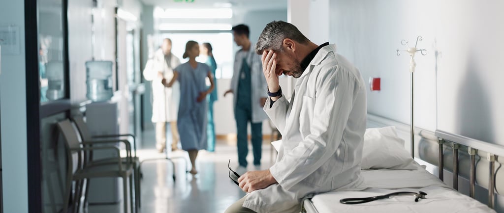 frustrated healthcare worker sitting on gurney in hospital hallway