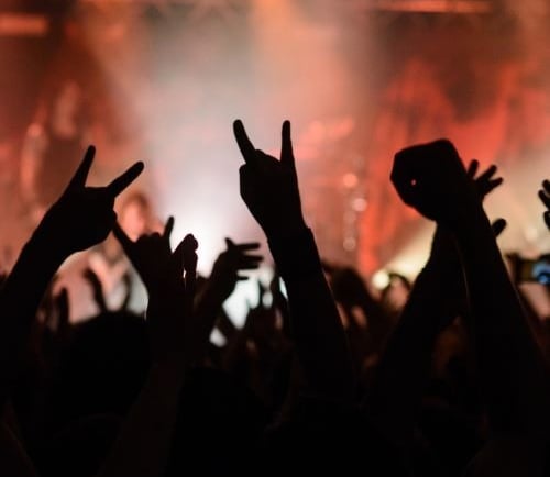 a crowd of people standing in front of a stage during a concert