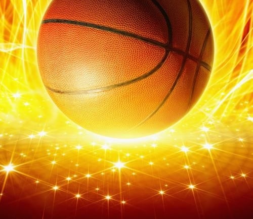 Textured orange basketball glowing against a vibrant background of fire and sparkling golden lights.