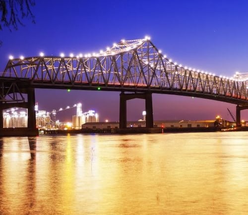 a bridge spanning a river with a bridge in the background