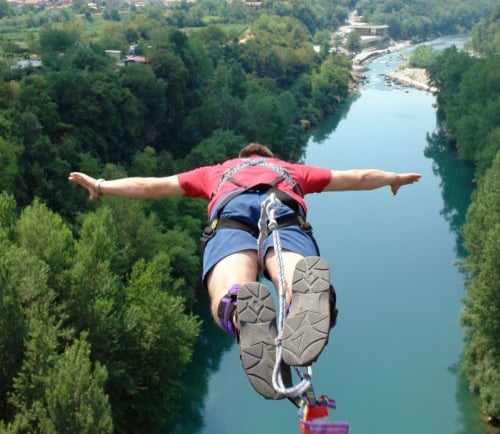 a man is hanging upside down on a rope