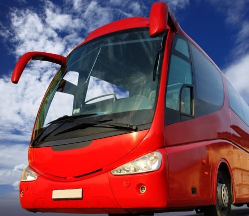 a red bus is driving down the road