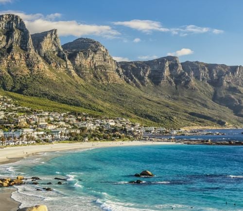 Panoramic view of Camps Bay beach in Cape Town with the Twelve Apostles mountain range.