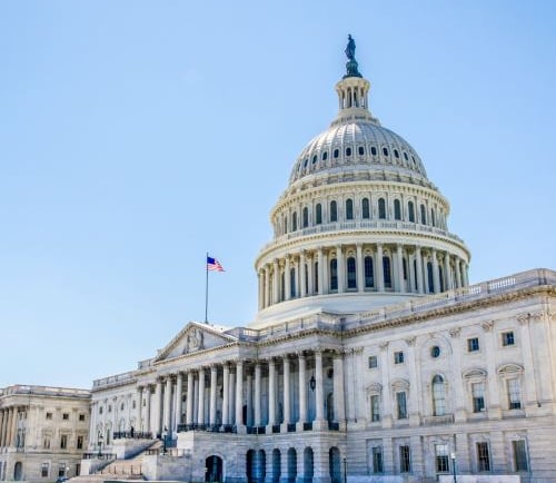 capitol - large white building with a flag on top of it