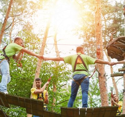 a group of people on a rope - tied rope course