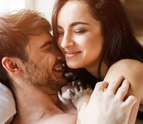 a man and woman are smiling and hugging