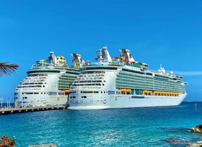two cruise ships docked at a dock in the ocean