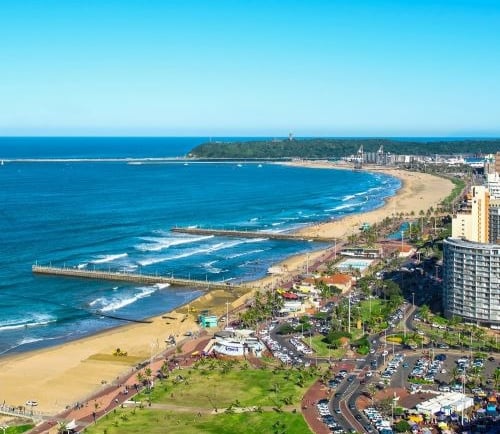 a beach with a view of the ocean and durban city