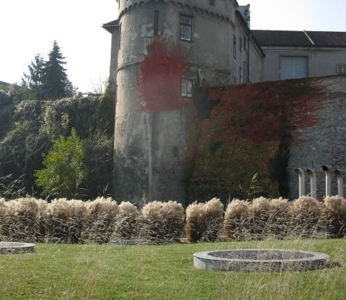 Historic stone castle tower with red autumn ivy and ornamental garden in Middelburg