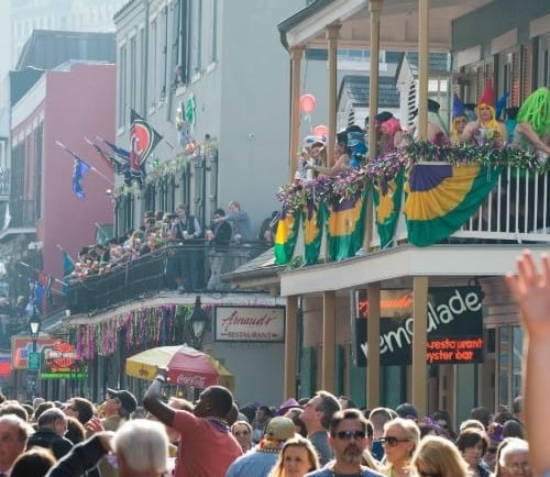 a crowd of people standing on a street  in New Orleans