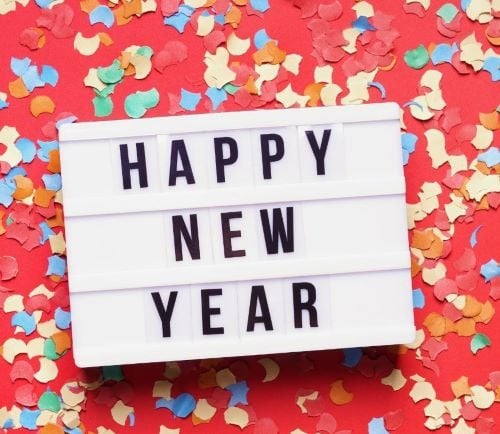 A white lightbox with Happy New Year text on a red background with colorful festive confetti.