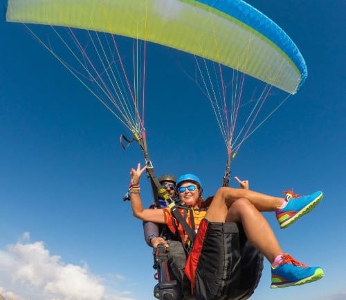 a man and woman parasailing in a parachute