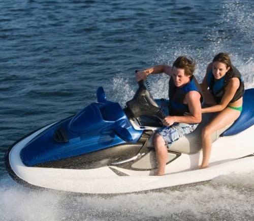 a man and woman riding a jet skis