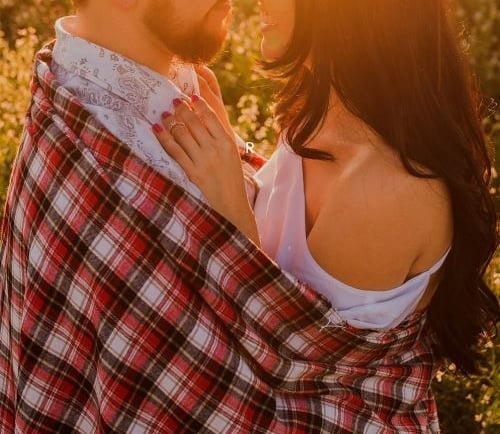 a man and woman standing in a field