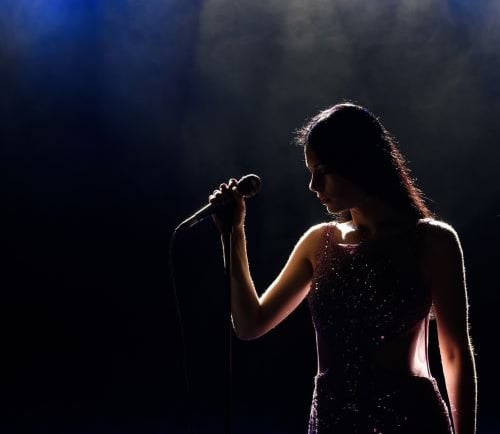 young woman singer is recording a song in a studio