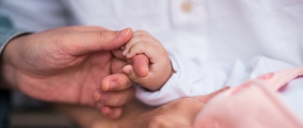 Little child holding the hands of Mother, with father supporting