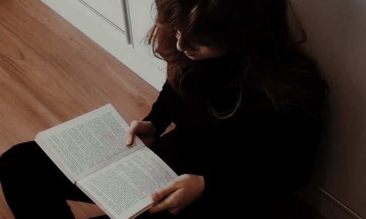 imagem de uma garota lendo um livro em uma sala de estar