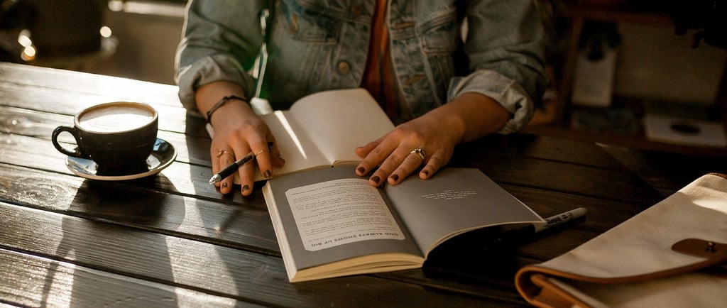 Image of a woman writing a book on a park table