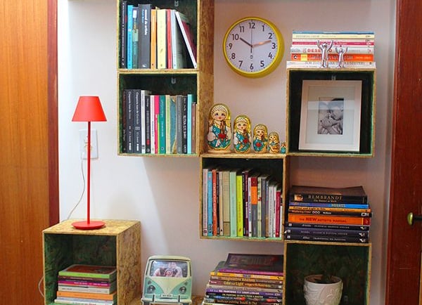 a bookshelf with books, decorations and a lamp