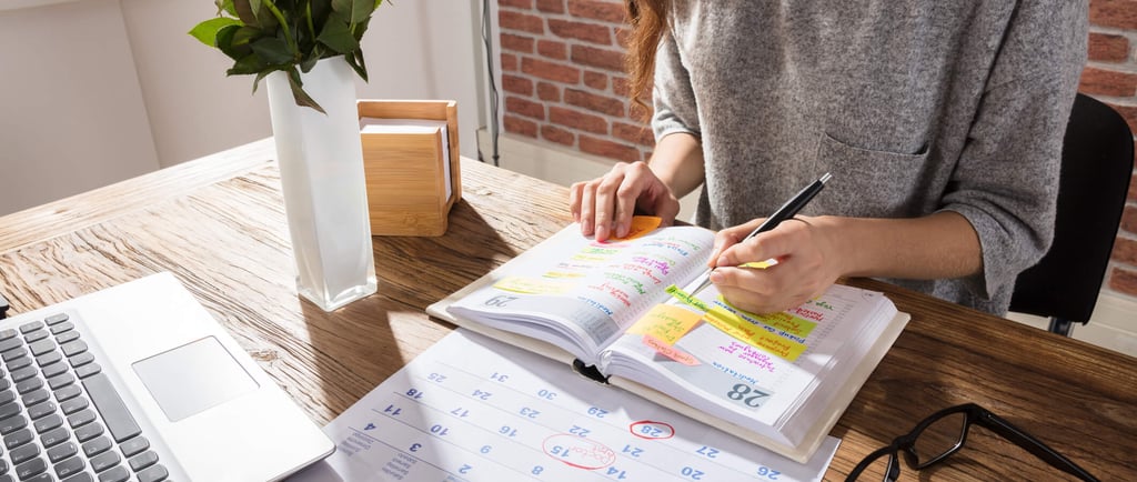 a woman sitting at a desk with a notebook and a notebook