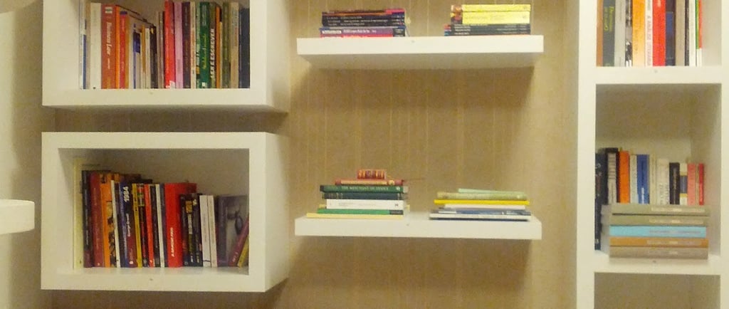 a room with a book shelf and a lamp