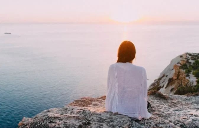 Personne assise face à la mer, symbole d’apaisement, de recentrage et de sérénité, en lien avec la pratique de la sophrologie