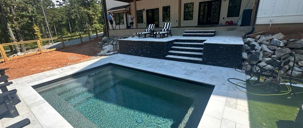 a pool with a deck and a deck with chairs
