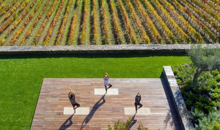 a group of people doing yoga on a wooden deck