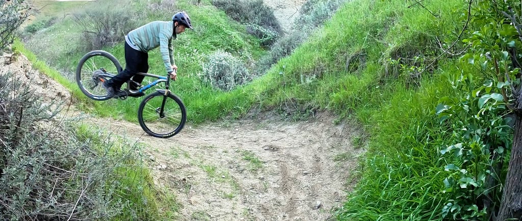 Mountain biker doing a stoppie pivot around a tight switchback