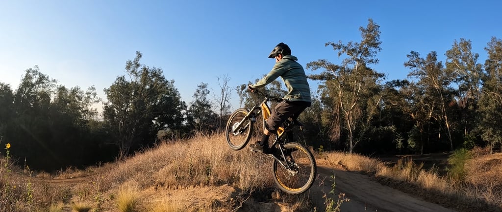 mountain biker tapping rear brake mid air to bring the front wheel down