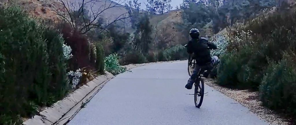Mountain bike rider practicing manual and wheelie techniques for skill building