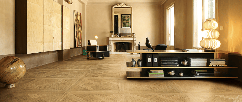 a living room with a large wooden floor and a fireplace