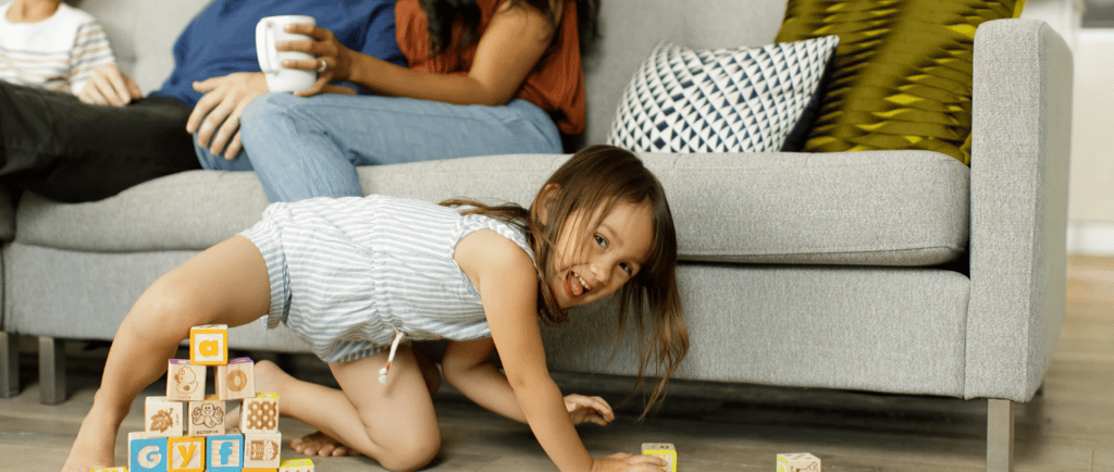 a young girl playing with blocks on the floor