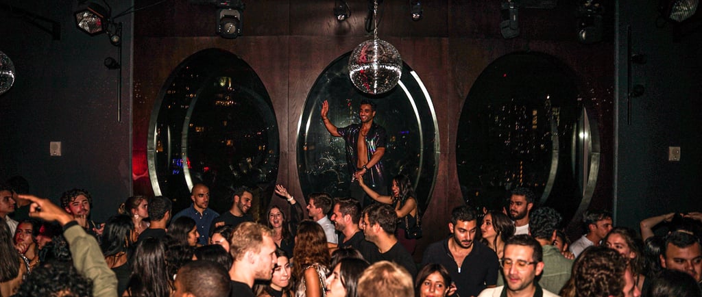 a man in a crowd of people standing around a disco