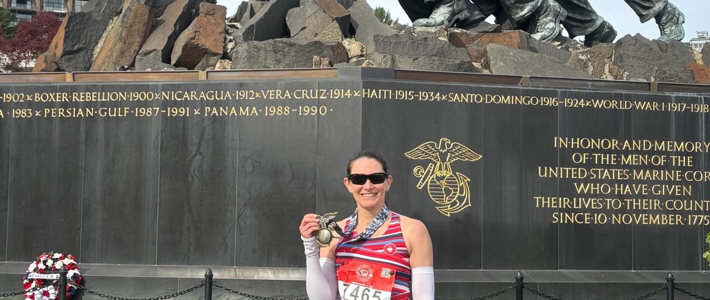 Marathon runner holding up a medal after finishing a race