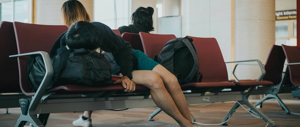 woman lying on a airport bench
