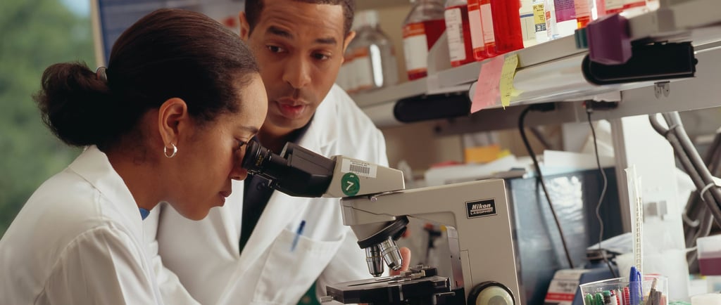 a female researcher observing under a electron microsope