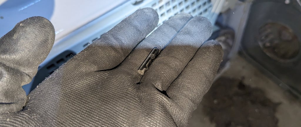 A person holding a pin in front of a clothes dryer