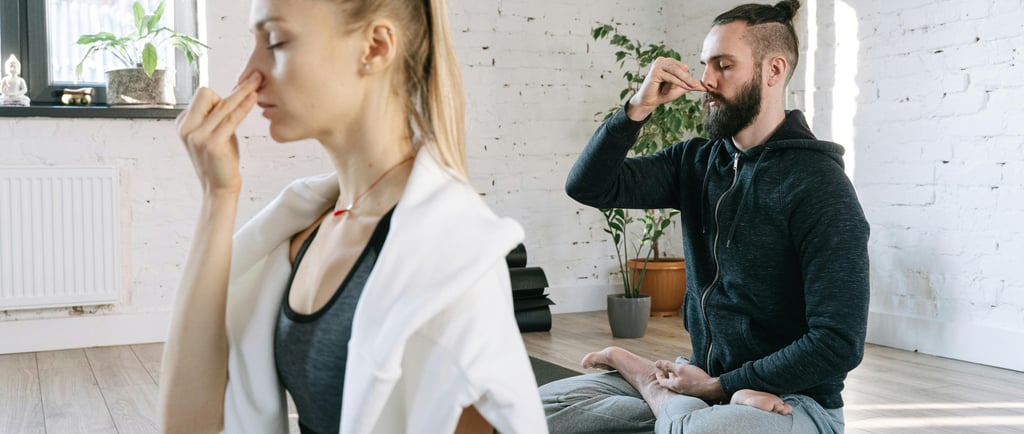 a man and woman sitting on a yoga mat