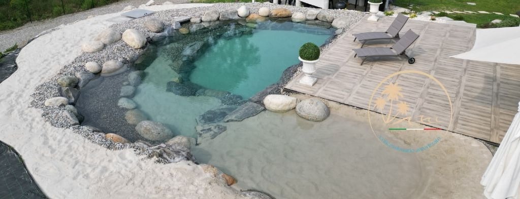 piscina con spiaggia bianca e zona solarium
