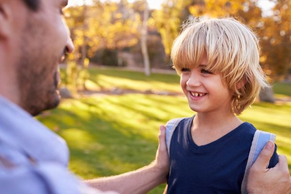 padre despidindo a su hijo en un campamento