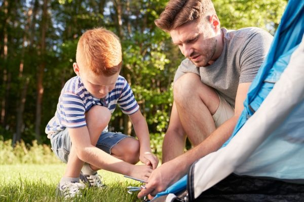 padre e hijo montando una tienda de campaña