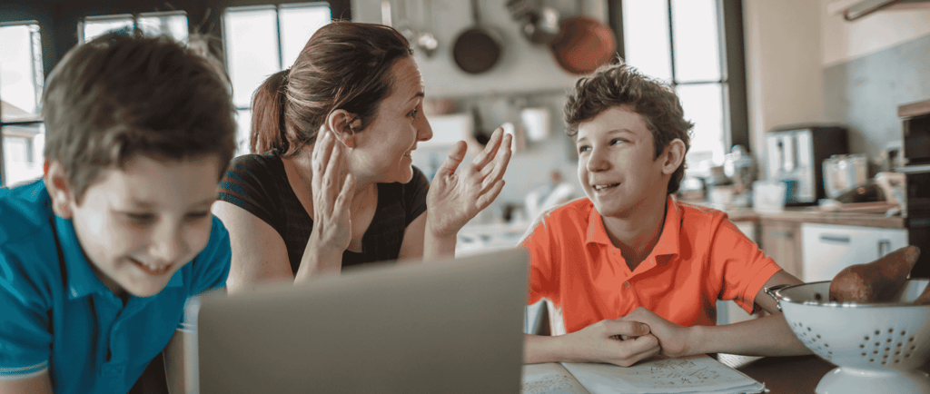 mother homeschooling two sons in the kitchen