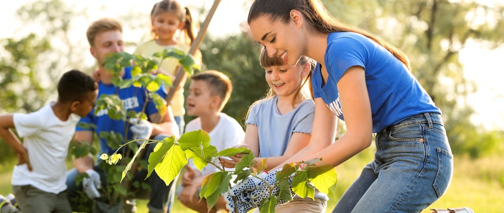 adults teaching homeschool children how to garden