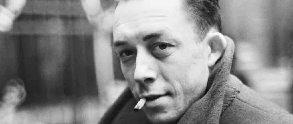 A black and white potrait of french writer ablert camus smoking a cigarette.