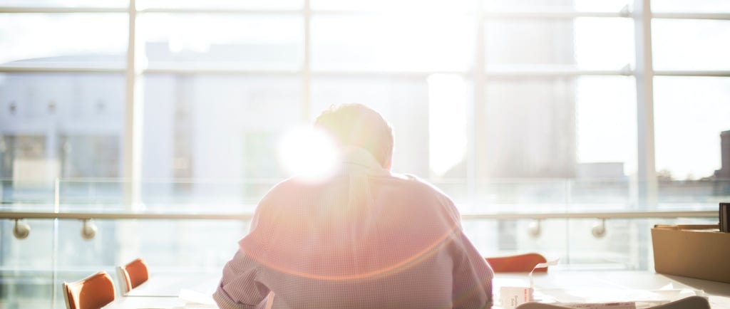 a person sitting at a table with a laptop