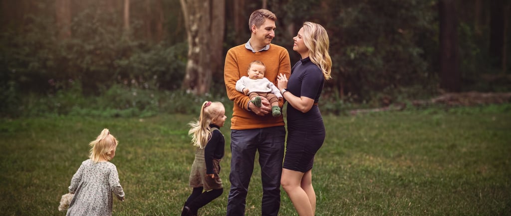 a family of three children and a baby in a field