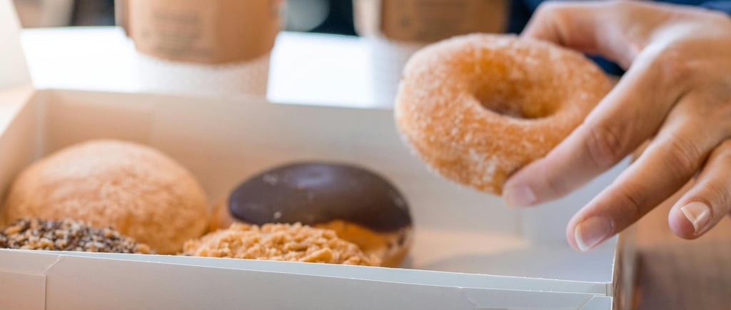 person taking donut from To Go box