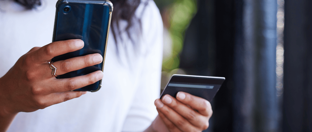 Woman holding cell phone and credit card